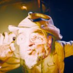 Primus’un The Ol’ Grizz resmî müzik videosundan Les Claypool görüntüsü.