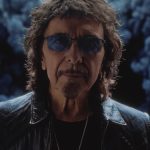 World Alone videosundan alınan karede Tony Iommi güneş gözlükleri ve siyah deri ceketiyle kameraya bakıyor.