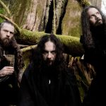 Wolves In The Throne Room'un üç üyesini yosunlu bir ormanda gösteren grup fotoğrafı