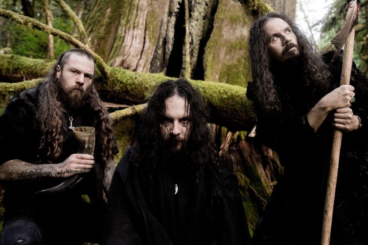 Wolves In The Throne Room'un üç üyesini yosunlu bir ormanda gösteren grup fotoğrafı